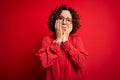 Middle age beautiful curly hair woman wearing casual shirt and glasses over red background Tired hands covering face, depression Royalty Free Stock Photo