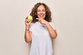 Middle age beautiful  sportswoman holding tennis ball over isolated white background smiling happy pointing with hand and finger Royalty Free Stock Photo