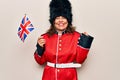 Middle age beautiful wales guard woman wearing traditional uniform holding united kingdom flag screaming proud, celebrating Royalty Free Stock Photo