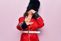 Middle age beautiful wales guard woman wearing traditional uniform over pink background covering eyes with hands and doing stop Royalty Free Stock Photo