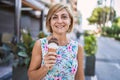 Middle age beautiful woman holding ice cream at park Royalty Free Stock Photo