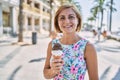 Middle age beautiful woman holding ice cream at street Royalty Free Stock Photo