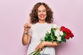 Middle age beautiful woman holding nature bouquet of flowers over isolated pink background smiling with an idea or question Royalty Free Stock Photo