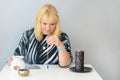 Portrait of beautiful middle age woman sits near a fortune teller desk with a tarot cards, black pendulum and candles. Royalty Free Stock Photo