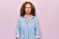 Middle age beautiful woman wearing casual denim shirt standing over pink background Relaxed with serious expression on face Royalty Free Stock Photo