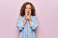 Middle age beautiful woman wearing casual denim shirt standing over pink background Tired hands covering face, depression and Royalty Free Stock Photo