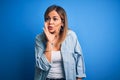 Middle age beautiful woman wearing casual shirt standing over isolated blue background hand on mouth telling secret rumor, Royalty Free Stock Photo