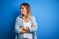 Middle age beautiful woman wearing casual shirt standing over isolated blue background looking to the side with arms crossed Royalty Free Stock Photo