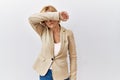 Middle age blonde business woman standing over isolated background covering eyes with arm, looking serious and sad Royalty Free Stock Photo