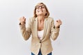 Middle age blonde business woman standing over isolated background excited for success with arms raised and eyes closed Royalty Free Stock Photo