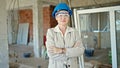 Middle age blonde woman architect smiling confident standing with arms crossed gesture at construction site Royalty Free Stock Photo