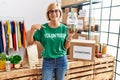 Middle age blonde woman wearing volunteer t shirt holding charity money pointing finger to one self smiling happy and proud