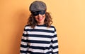 Middle age brunette burglar woman wearing mask and cap standing over yellow background with a happy and cool smile on face Royalty Free Stock Photo