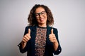 Middle age brunette business woman wearing glasses standing over isolated white background success sign doing positive gesture Royalty Free Stock Photo