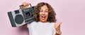 Middle age brunette hipster woman holding retro music boombox over pink isolated background pointing thumb up to the side smiling Royalty Free Stock Photo