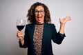 Middle age brunette woman drinking glass of red wine over isolated white background very happy and excited, winner expression Royalty Free Stock Photo