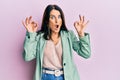 Middle age brunette woman wearing casual clothes looking surprised and shocked doing ok approval symbol with fingers Royalty Free Stock Photo
