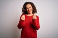 Middle age brunette woman wearing casual sweater standing over isolated white background doing money gesture with hands, asking Royalty Free Stock Photo