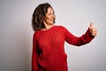 Middle age brunette woman wearing casual sweater standing over isolated white background Looking proud, smiling doing thumbs up Royalty Free Stock Photo