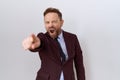 Middle age business man with beard wearing suit and tie pointing displeased and frustrated to the camera, angry and furious with Royalty Free Stock Photo