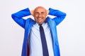 Middle age businessman wearing suit standing over isolated white background relaxing and stretching, arms and hands behind head Royalty Free Stock Photo