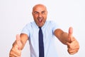 Middle age businessman wearing tie standing over isolated white background approving doing positive gesture with hand, thumbs up Royalty Free Stock Photo