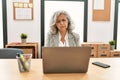 Middle age businesswoman sitting on desk working using laptop at office depressed and worry for distress, crying angry and afraid Royalty Free Stock Photo