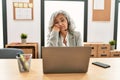 Middle age businesswoman sitting on desk working using laptop at office thinking looking tired and bored with depression problems Royalty Free Stock Photo