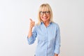 Middle age businesswoman wearing elegant shirt and glasses over isolated white background doing happy thumbs up gesture with hand Royalty Free Stock Photo