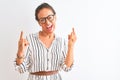 Middle age businesswoman wearing striped dress and glasses over isolated white background shouting with crazy expression doing Royalty Free Stock Photo