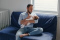 Middle age Caucasian father feeding newborn baby from bottle milk. Man parent holding rocking a child on his hands. Authentic Royalty Free Stock Photo