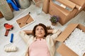 Middle age caucasian woman relaxed lying on the floor at new home Royalty Free Stock Photo