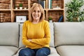 Middle age caucasian woman wearing casual clothes sitting on the sofa at home happy face smiling with crossed arms looking at the Royalty Free Stock Photo