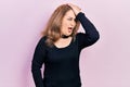 Middle age caucasian woman wearing casual clothes surprised with hand on head for mistake, remember error Royalty Free Stock Photo