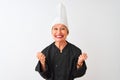 Middle age chef woman wearing uniform and hat standing over isolated white background celebrating surprised and amazed for success Royalty Free Stock Photo