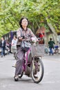 Middle-age Chinese woman on electric bike with basket, Yangzhou, China