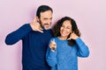 Middle age couple of hispanic woman and man holding keys of new home smiling doing phone gesture with hand and fingers like Royalty Free Stock Photo