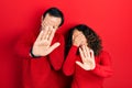 Middle age couple of hispanic woman and man hugging and standing together covering eyes with hands and doing stop gesture with sad Royalty Free Stock Photo