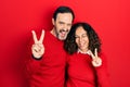 Middle age couple of hispanic woman and man hugging and standing together smiling with happy face winking at the camera doing Royalty Free Stock Photo