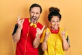 Middle age couple of hispanic woman and man wearing sportswear and arm band shouting with crazy expression doing rock symbol with Royalty Free Stock Photo