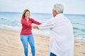 Middle age couple in love dancing at the beach happy and cheerful together Royalty Free Stock Photo