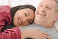 Middle-age couple relaxing together on their bed Royalty Free Stock Photo
