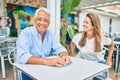 Middle age couple in love sitting at the terrace of coffee shop happy and cheerful together Royalty Free Stock Photo