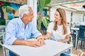 Middle age couple in love sitting at the terrace of coffee shop happy and cheerful together Royalty Free Stock Photo