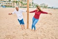 Middle age couple in love walking having fun ath the beach happy and cheerful together Royalty Free Stock Photo