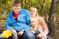 Middle-age couple with one girl sitting on a bench Royalty Free Stock Photo