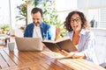 Middle age couple relaxing at home terrace pointing thumb up to the side smiling happy with open mouth Royalty Free Stock Photo