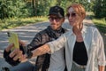 Middle age couple riding a motorcycle having fun and taking a selfie on a mobile phone camera Royalty Free Stock Photo