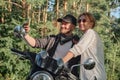 Middle age couple riding a motorcycle having fun and taking a selfie on a mobile phone camera Royalty Free Stock Photo