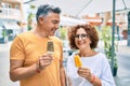 Middle age couple smiling happy eating ice cream at street of city Royalty Free Stock Photo